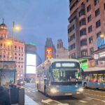 un bus 001 en la gran via de madrid al atardecer