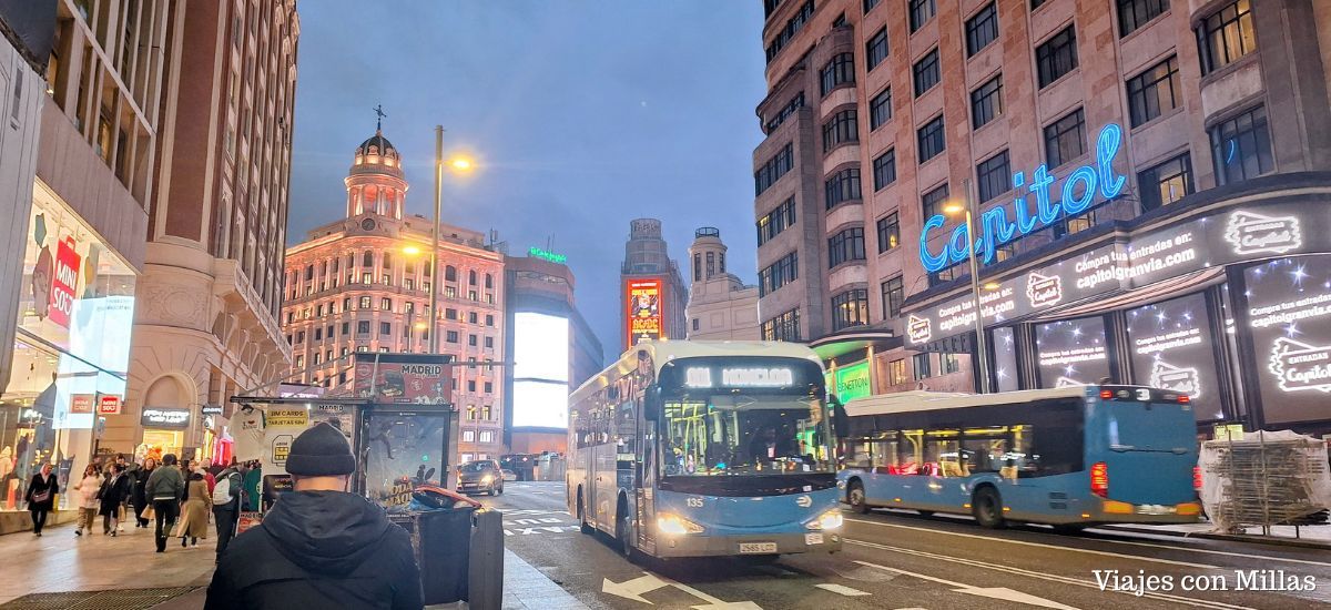 un bus 001 en la gran via de madrid al atardecer
