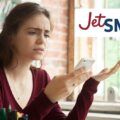 mujer ofuscada mirando el teléfono junto a un logo de jetsmart